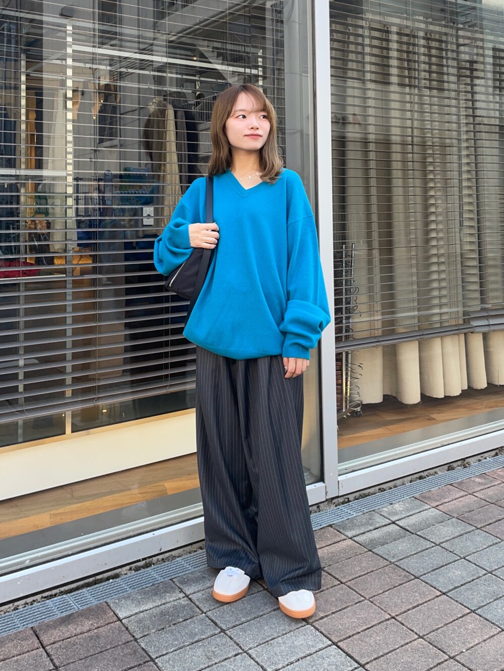 その他のその他パンツ、ゴールド系のスニーカー、ブルー系のニット/セーターを着用したレディースの秋コーディネートの7枚目の写真