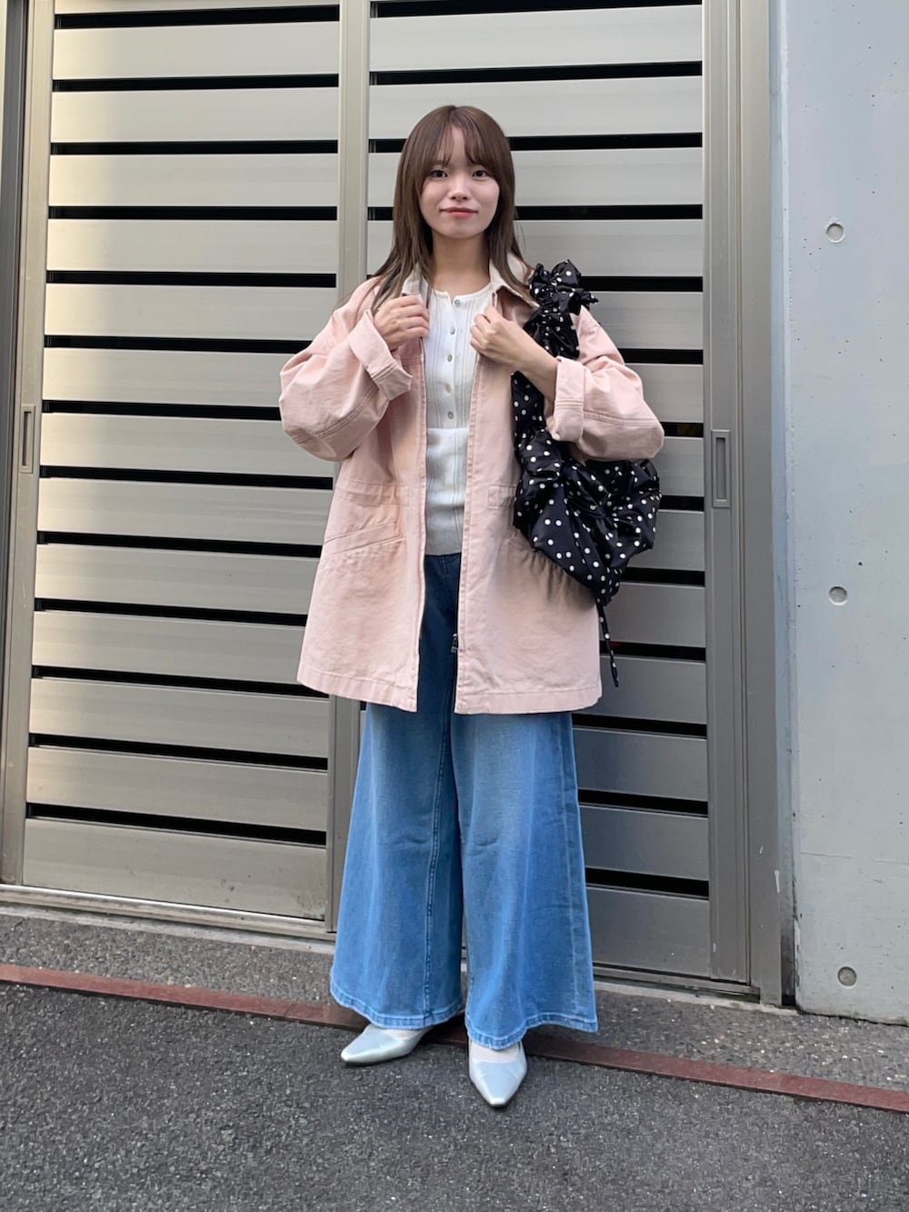 ピンク系のカバーオール、ブラック系のショルダーバッグ、ホワイト系のニット/セーターを着用したレディースの春コーディネートの6枚目の写真