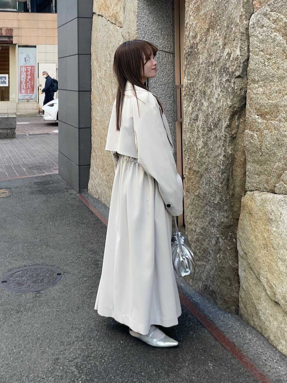 ベージュ系のTシャツ/カットソー、ブラック系のスカート、シルバー系のショルダーバッグを着用したレディースの春コーディネートの5枚目の写真