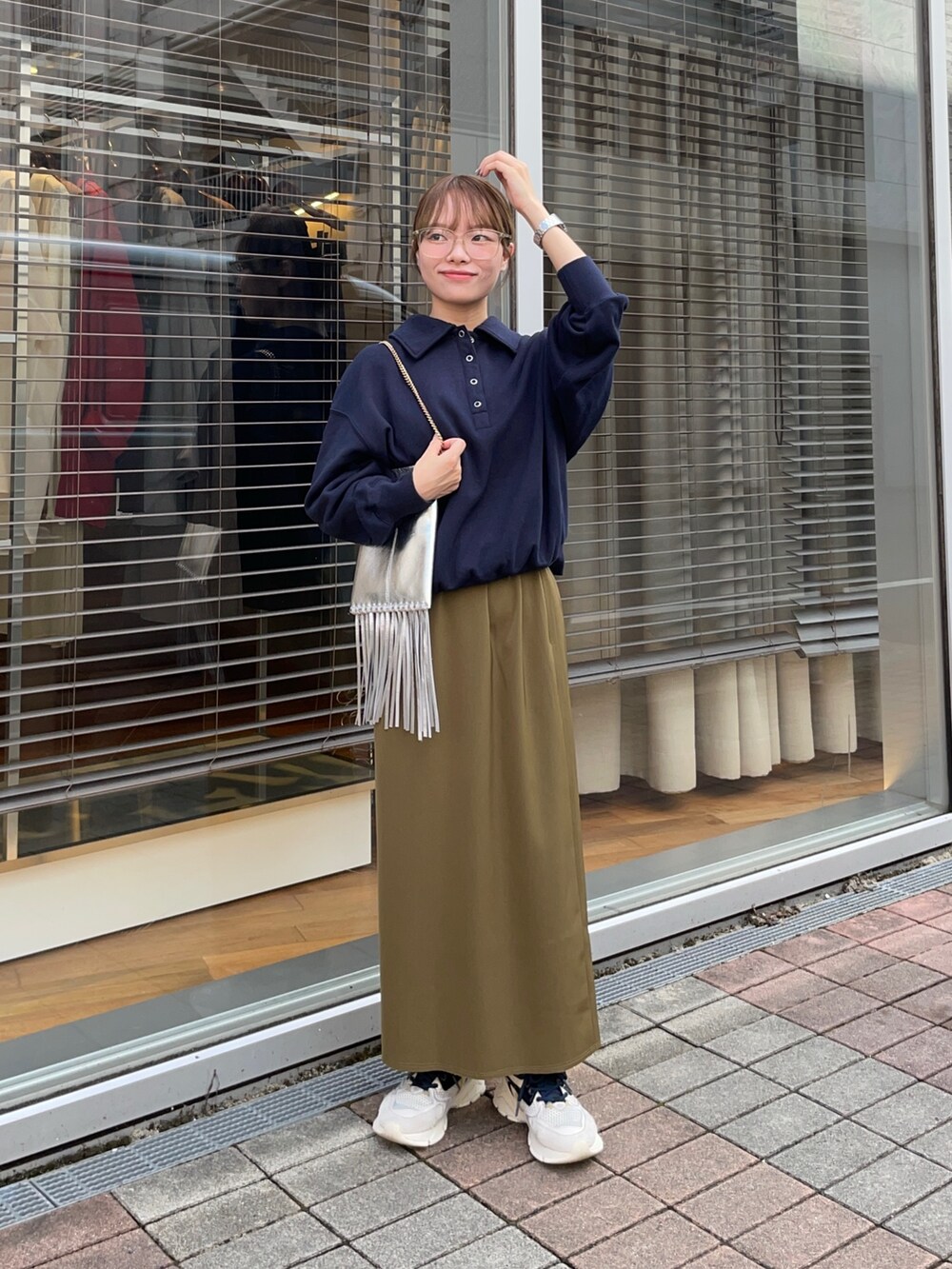 ブルー系のスウェット、グリーン系のスカート、シルバー系のショルダーバッグを着用したレディースの秋コーディネートの6枚目の写真