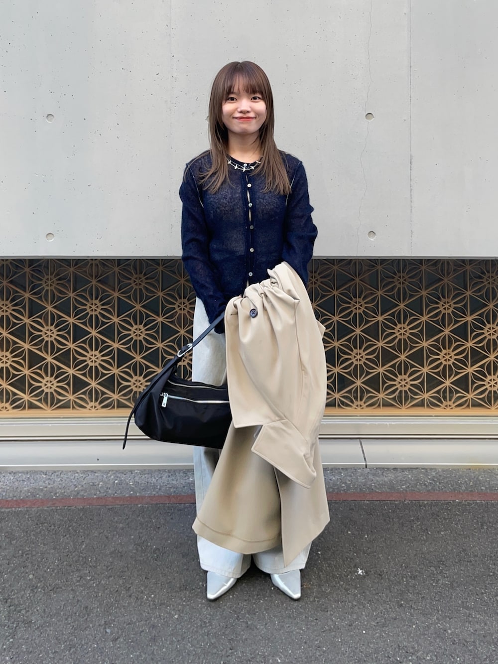 ベージュ系のトレンチコート、ブルー系のカーディガン/ボレロ、グレー系のデニムパンツを着用したレディースの冬コーディネートの9枚目の写真