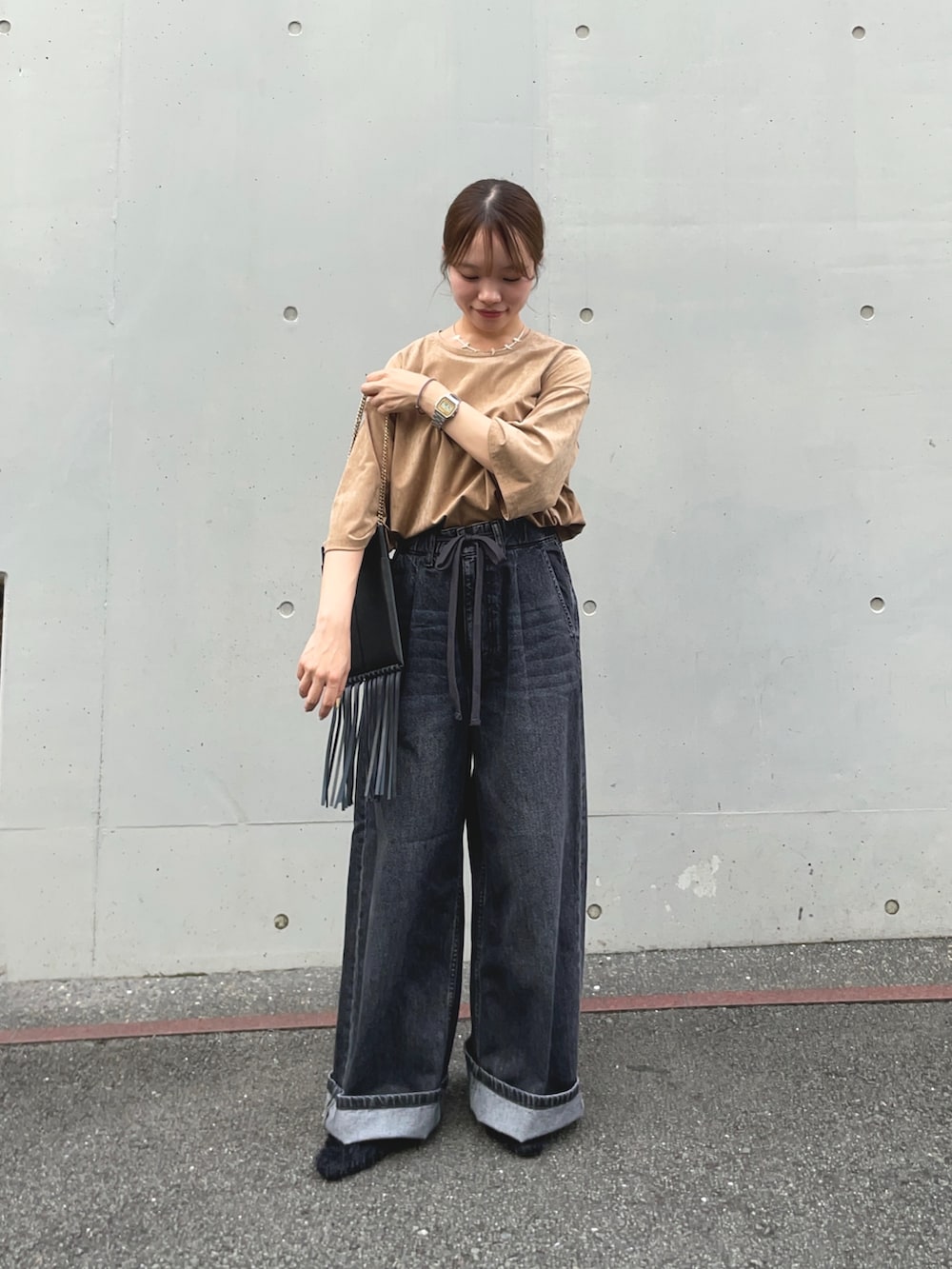 ブラック系のデニムパンツ、ベージュ系のTシャツ/カットソー、ブラック系のその他シューズを着用したレディースの秋コーディネートの5枚目の写真