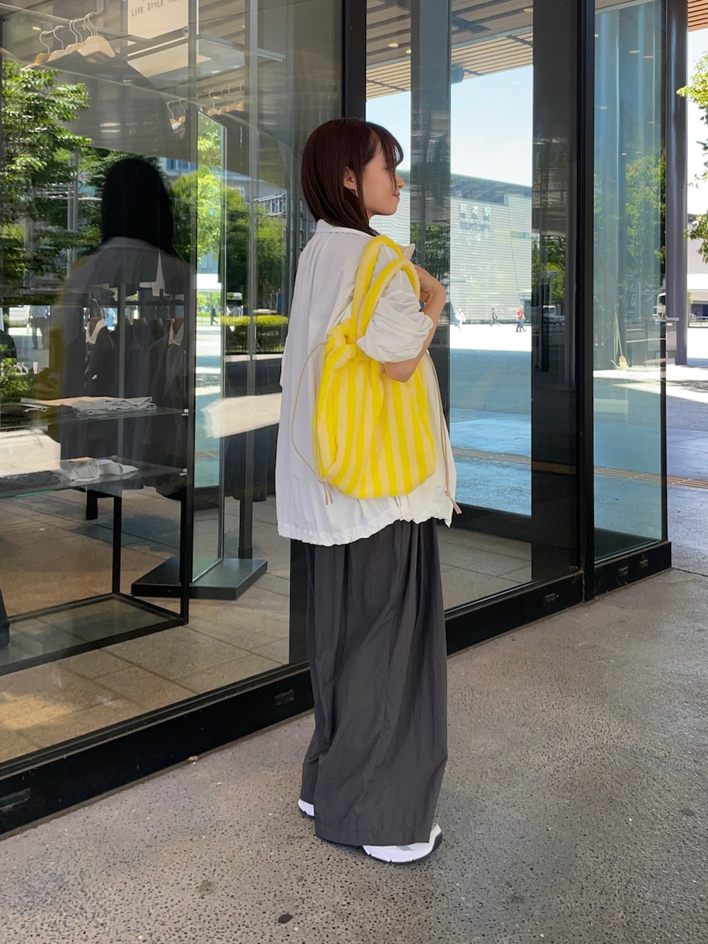ホワイト系のブルゾン、グレー系のスニーカー、グレー系のその他パンツを着用したレディースの春コーディネートの6枚目の写真