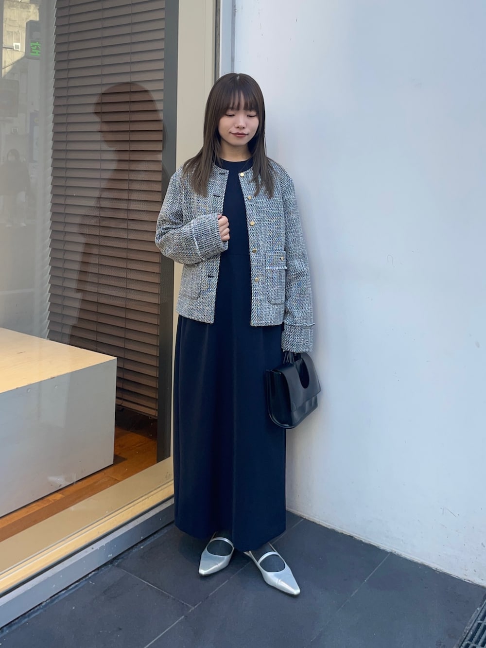 ブラック系のノーカラージャケット、ブルー系のワンピース、シルバー系のパンプスを着用したレディースの冬コーディネートの7枚目の写真