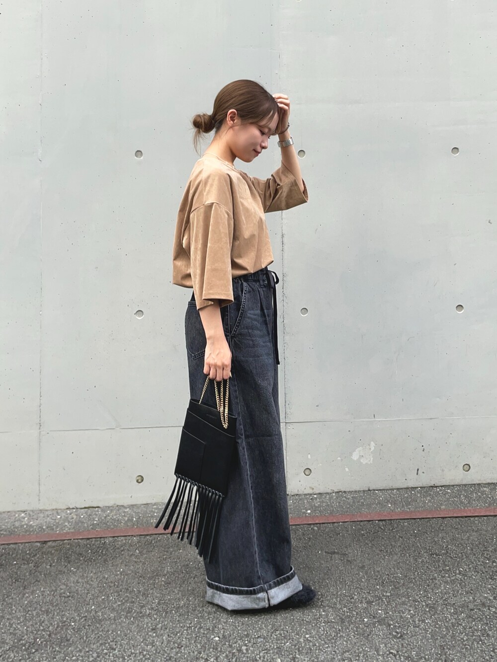 ブラック系のデニムパンツ、ベージュ系のTシャツ/カットソー、ブラック系のその他シューズを着用したレディースの秋コーディネートの4枚目の写真