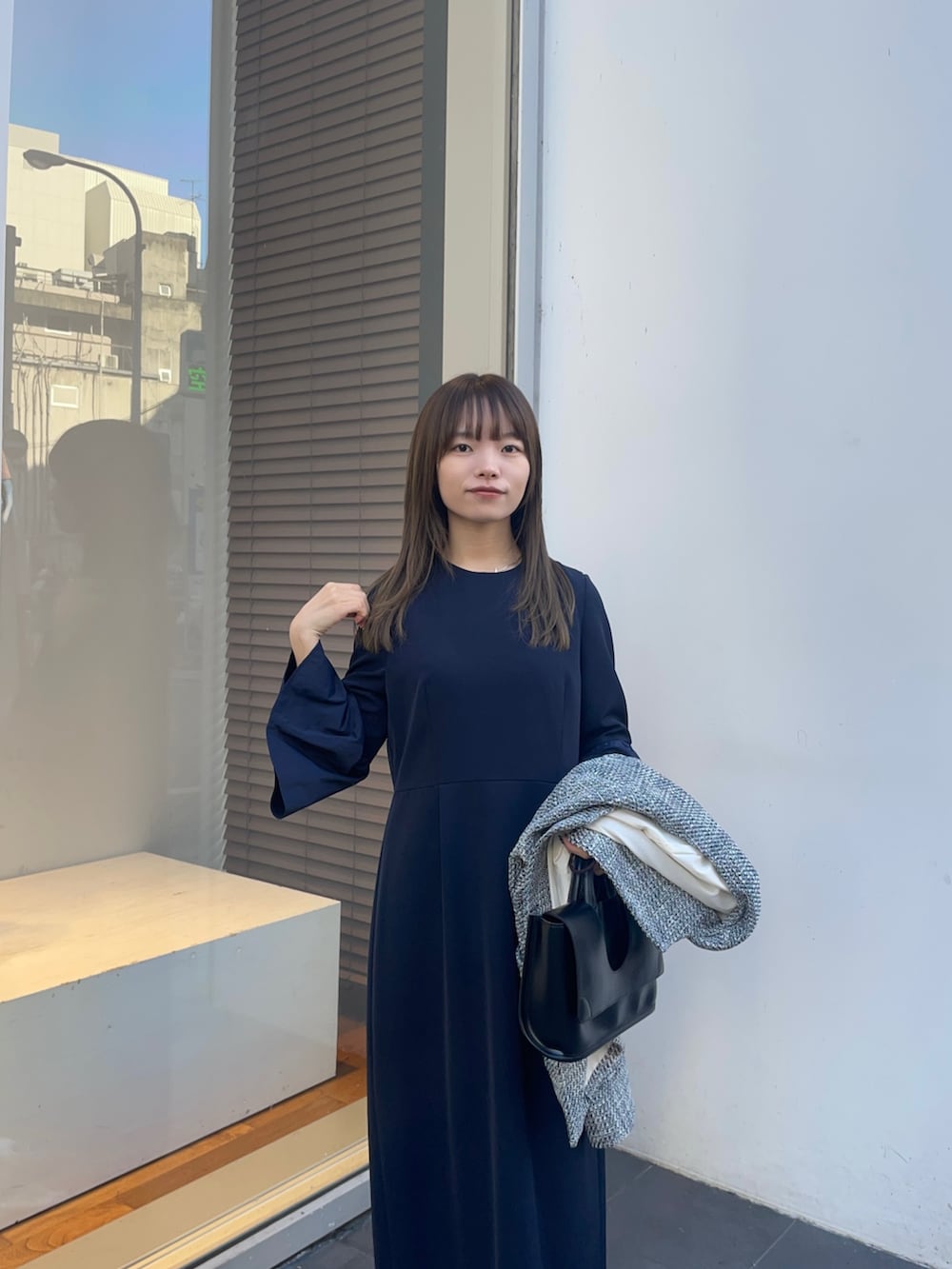 ブラック系のノーカラージャケット、ブルー系のワンピース、シルバー系のパンプスを着用したレディースの冬コーディネートの9枚目の写真