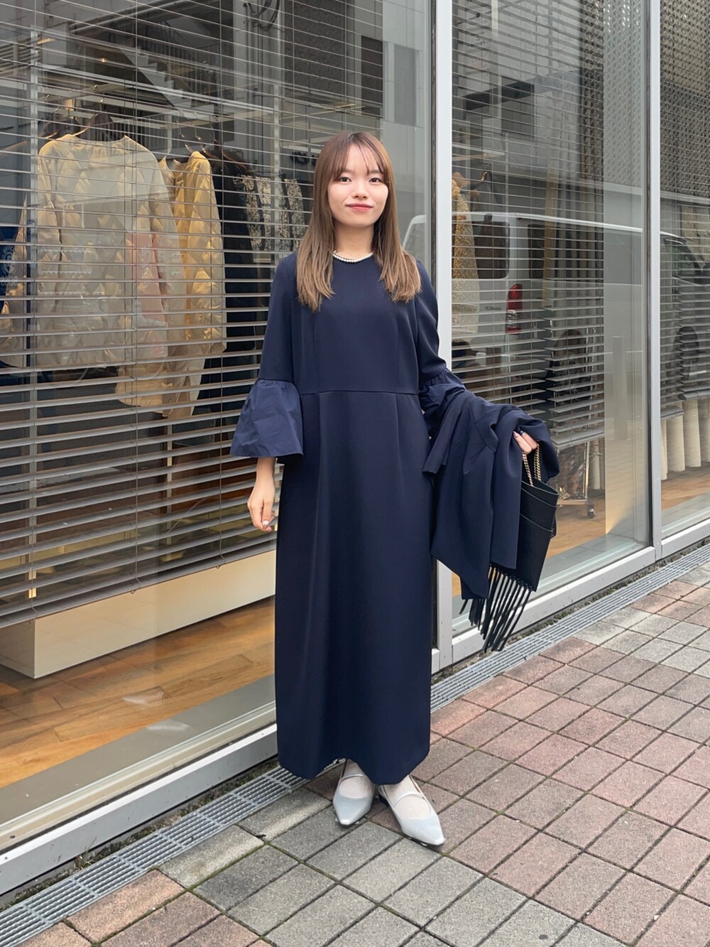 ブルー系のノーカラージャケット、ブルー系のワンピース、シルバー系のパンプスを着用したレディースの冬コーディネートの2枚目の写真
