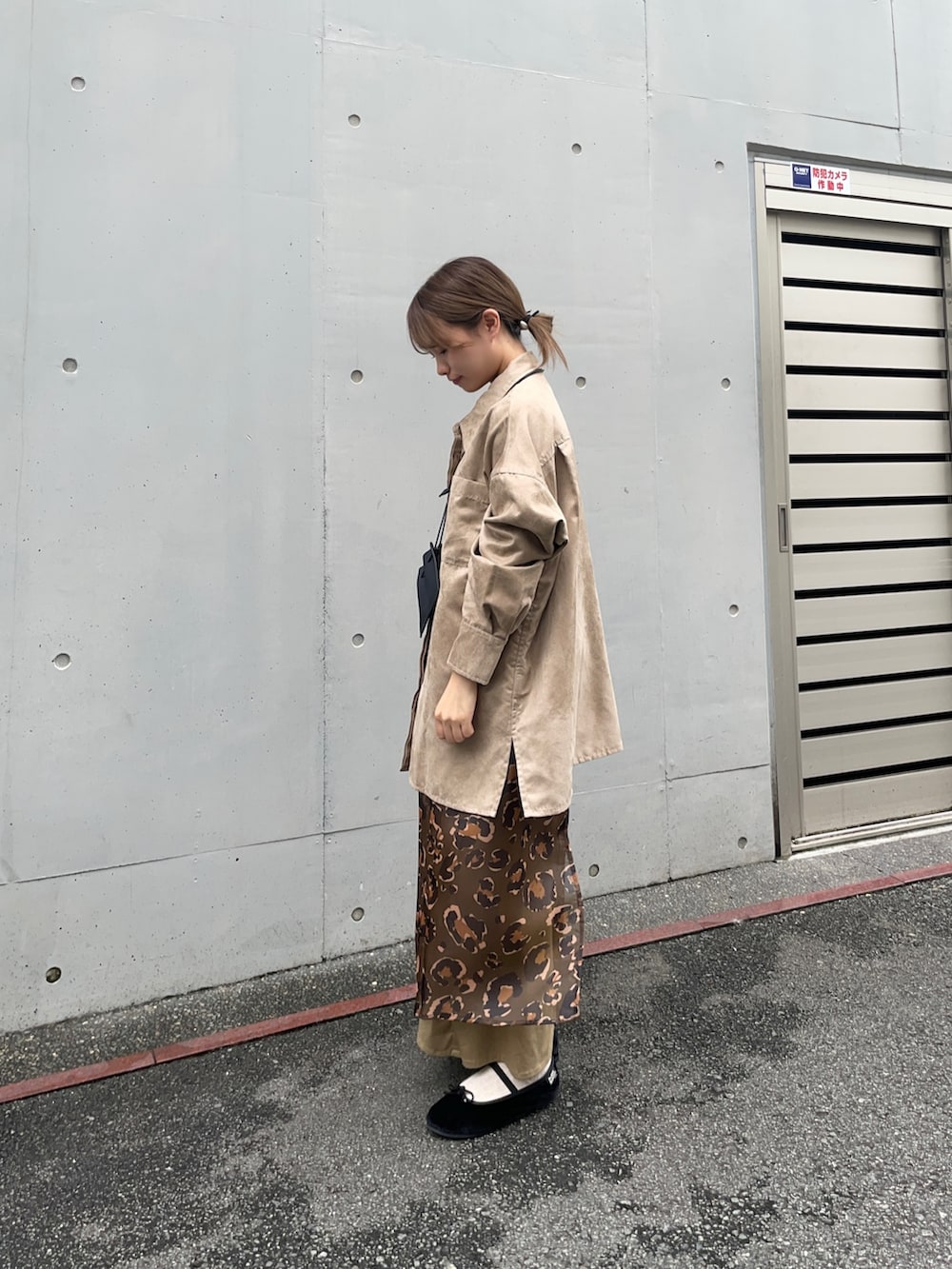 ベージュ系のシャツ/ブラウス、グリーン系のスカート、ブラック系のポーチを着用したレディースの夏コーディネートの3枚目の写真