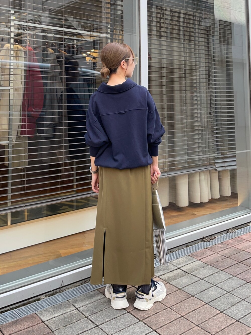 ブルー系のスウェット、グリーン系のスカート、シルバー系のショルダーバッグを着用したレディースの秋コーディネートの4枚目の写真