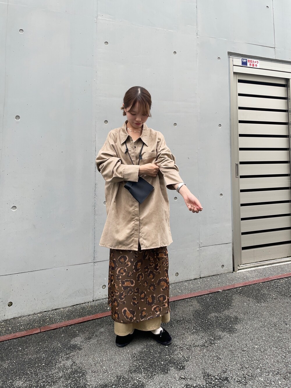 ベージュ系のシャツ/ブラウス、グリーン系のスカート、ブラック系のポーチを着用したレディースの夏コーディネートの7枚目の写真