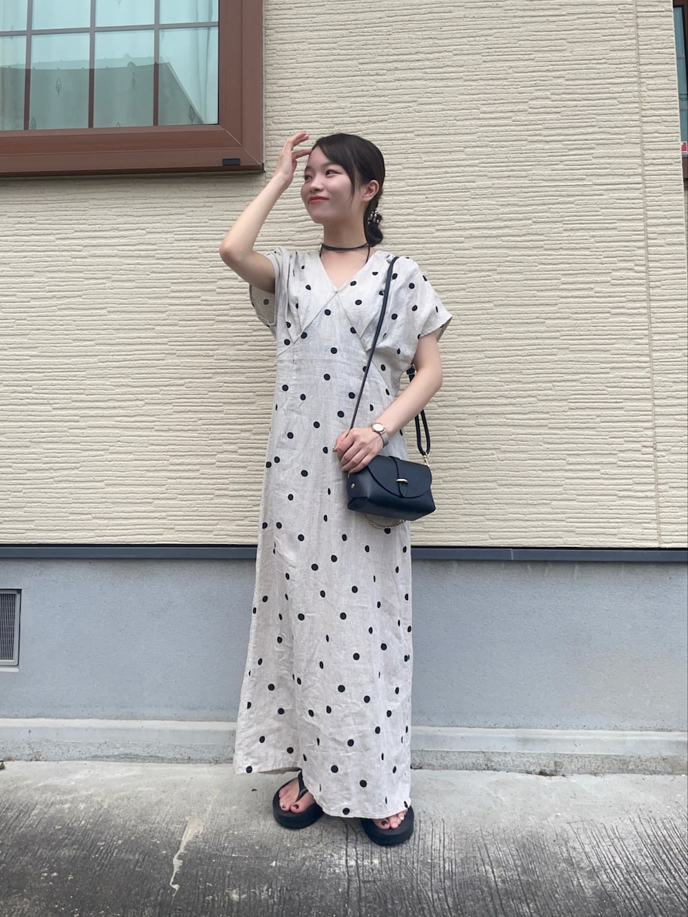 ベージュ系のワンピース、ブラック系のショルダーバッグ、ブラック系のサンダルを着用したレディースの夏コーディネートの2枚目の写真