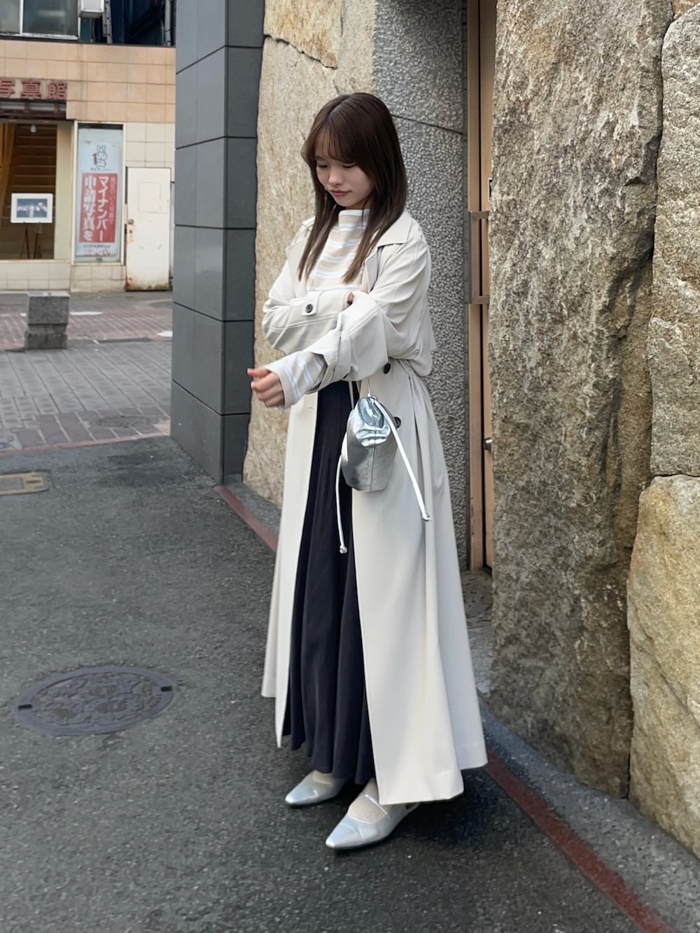 ベージュ系のTシャツ/カットソー、ブラック系のスカート、シルバー系のショルダーバッグを着用したレディースの春コーディネートの3枚目の写真