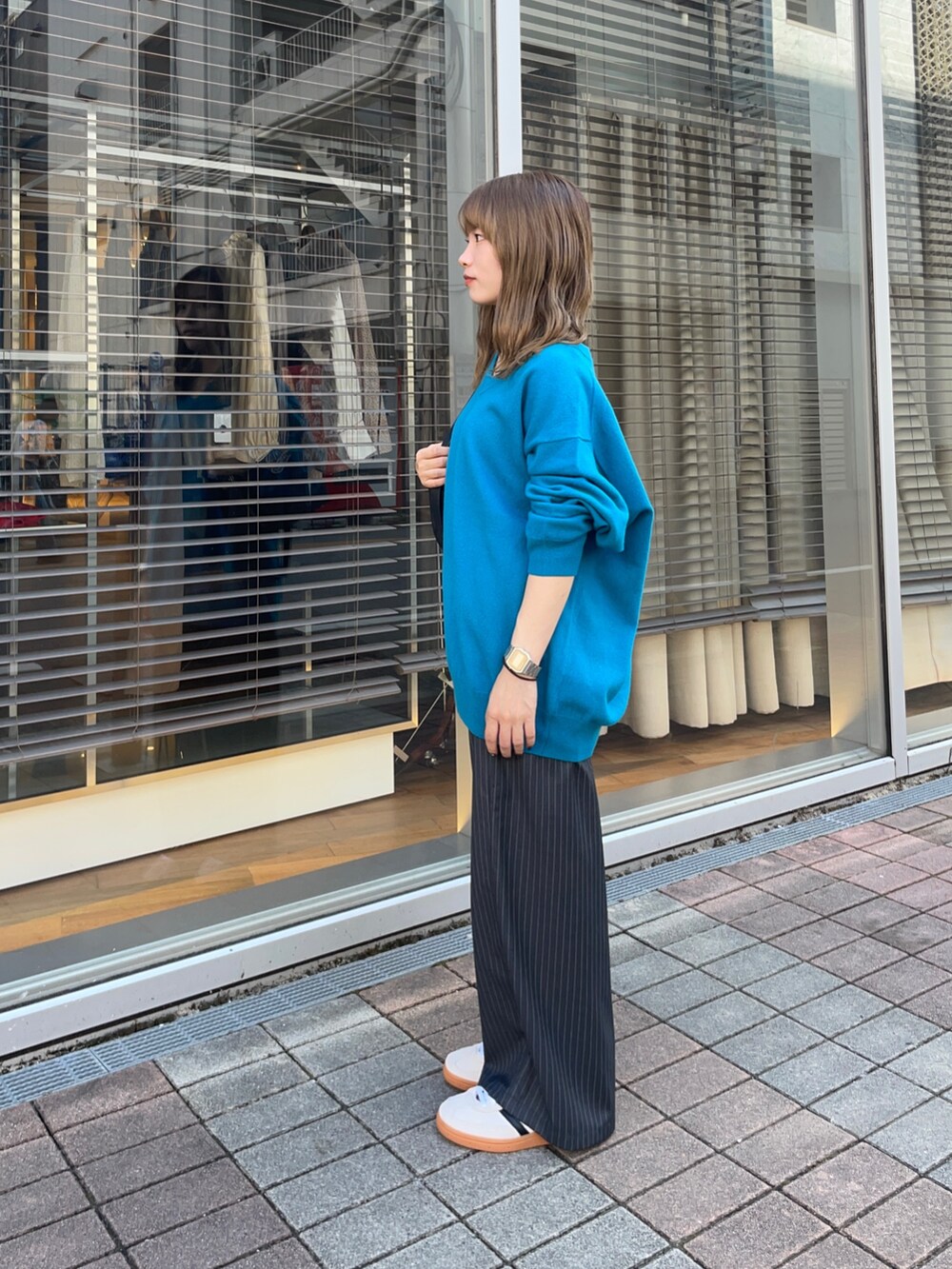 その他のその他パンツ、ゴールド系のスニーカー、ブルー系のニット/セーターを着用したレディースの秋コーディネートの3枚目の写真