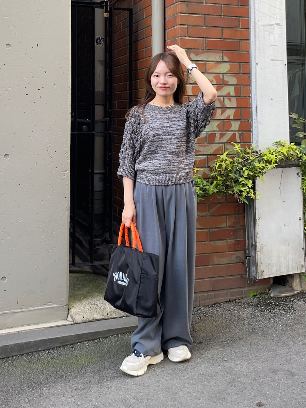 グレー系のニット/セーター、ブラック系のトートバッグ、グレー系のその他パンツを着用したレディースの春コーディネートの6枚目の写真