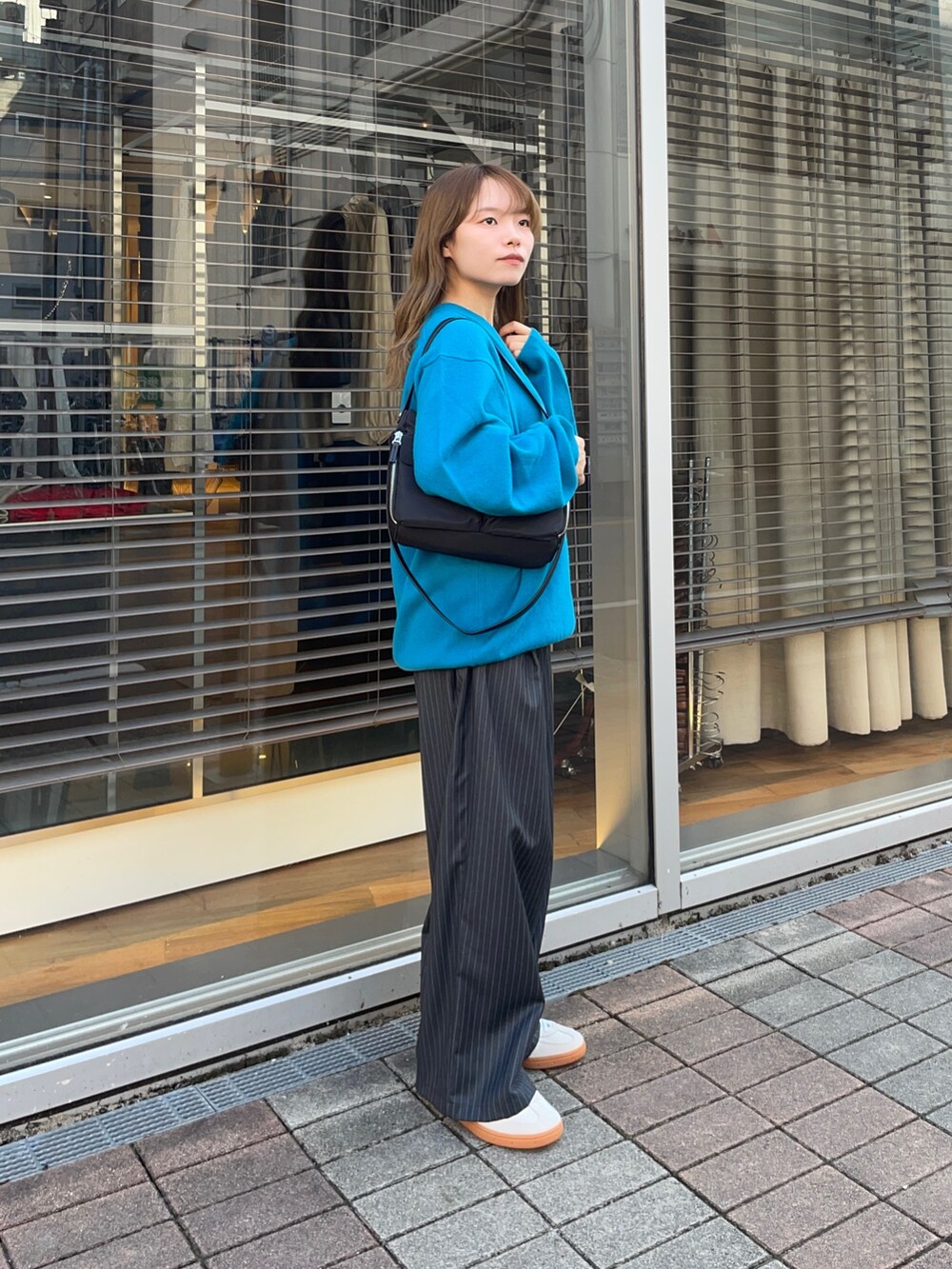 その他のその他パンツ、ゴールド系のスニーカー、ブルー系のニット/セーターを着用したレディースの秋コーディネートの5枚目の写真