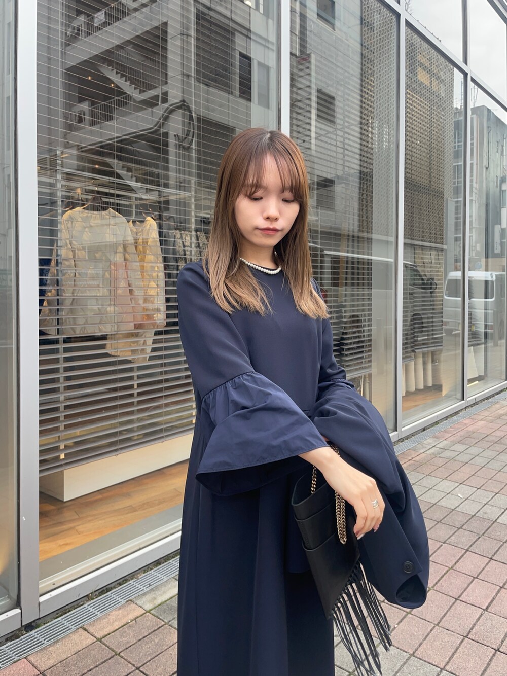 ブルー系のノーカラージャケット、ブルー系のワンピース、シルバー系のパンプスを着用したレディースの冬コーディネートの3枚目の写真