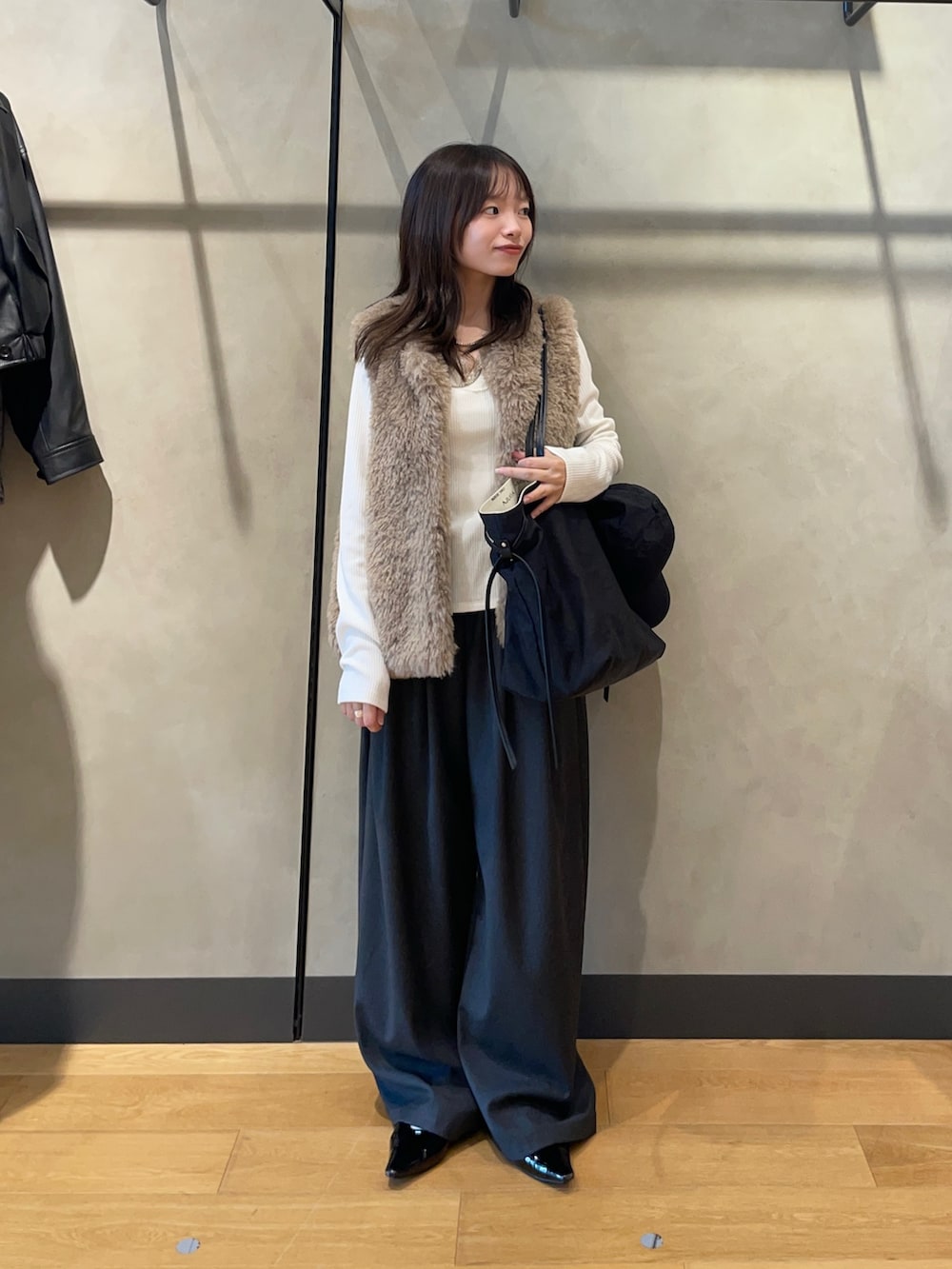 ホワイト系のTシャツ/カットソー、ブラック系のパンプス、ブラック系のトートバッグを着用したレディースの秋コーディネートの6枚目の写真