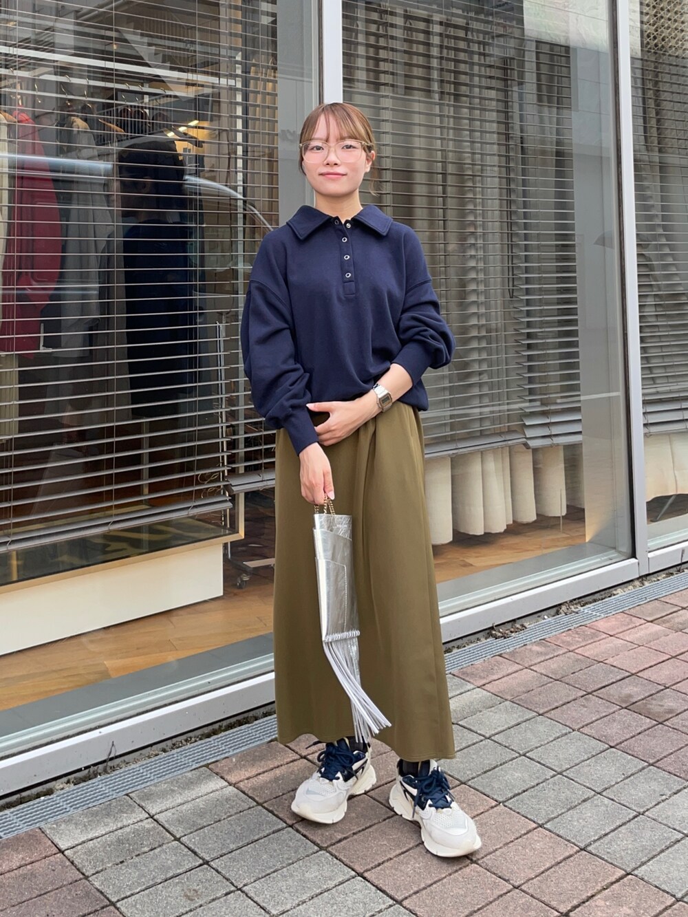 ブルー系のスウェット、グリーン系のスカート、シルバー系のショルダーバッグを着用したレディースの秋コーディネートの7枚目の写真