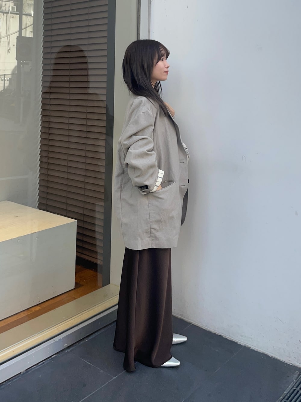 ベージュ系のその他アウター、ブラウン系のスカート、ホワイト系のタンクトップを着用したレディースの春コーディネートの5枚目の写真