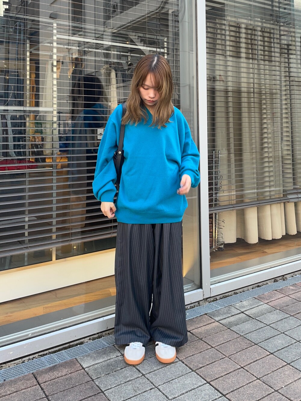 その他のその他パンツ、ゴールド系のスニーカー、ブルー系のニット/セーターを着用したレディースの秋コーディネートの2枚目の写真
