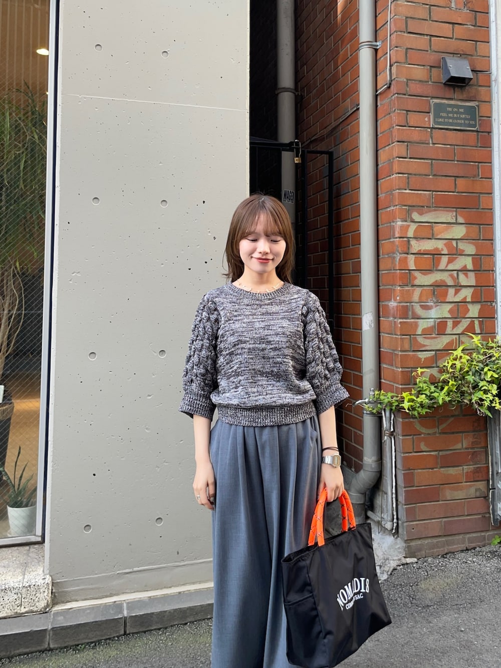 グレー系のニット/セーター、ブラック系のトートバッグ、グレー系のその他パンツを着用したレディースの春コーディネートの9枚目の写真