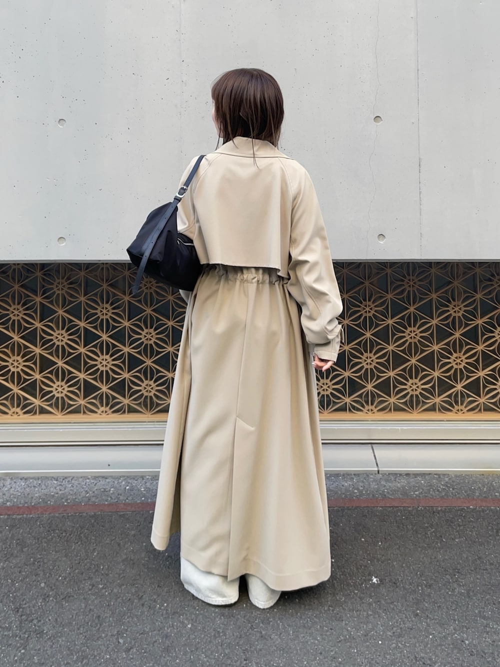 ベージュ系のトレンチコート、ブルー系のカーディガン/ボレロ、グレー系のデニムパンツを着用したレディースの冬コーディネートの4枚目の写真