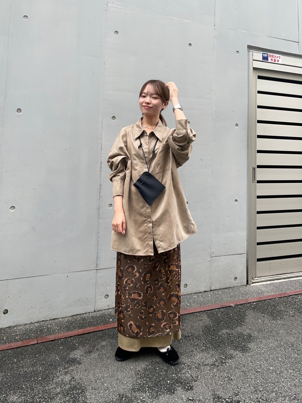 ベージュ系のシャツ/ブラウス、グリーン系のスカート、ブラック系のポーチを着用したレディースの夏コーディネートの8枚目の写真