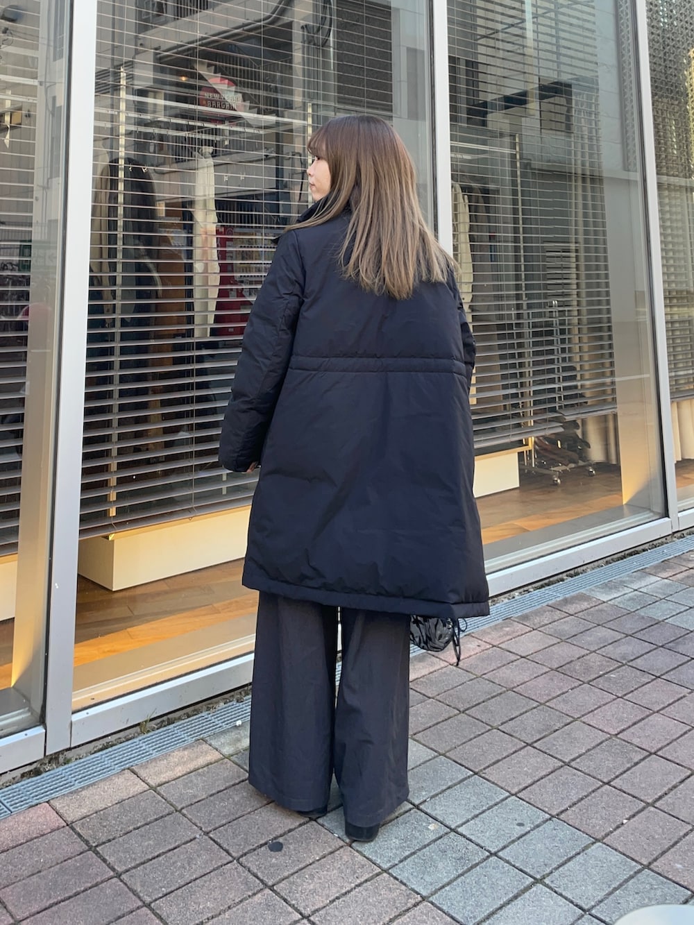 イエロー系のカーディガン/ボレロ、ホワイト系のTシャツ/カットソー、ブラック系のダウンジャケット/コートを着用したレディースの冬コーディネートの5枚目の写真