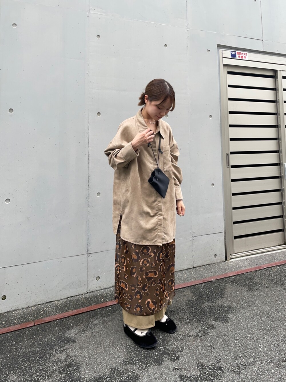 ベージュ系のシャツ/ブラウス、グリーン系のスカート、ブラック系のポーチを着用したレディースの夏コーディネートの6枚目の写真