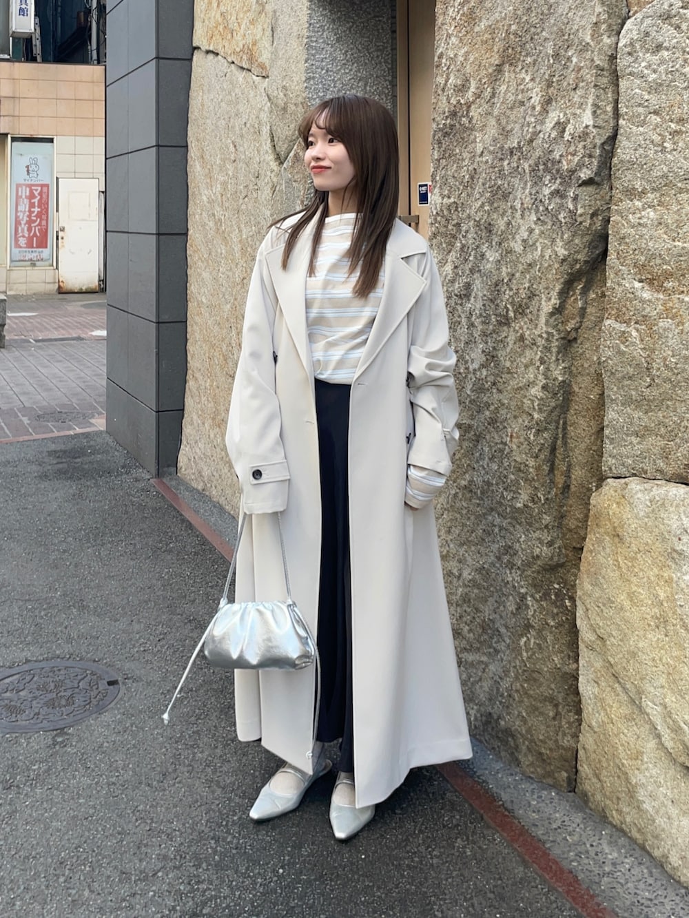 ベージュ系のTシャツ/カットソー、ブラック系のスカート、シルバー系のショルダーバッグを着用したレディースの春コーディネートの2枚目の写真