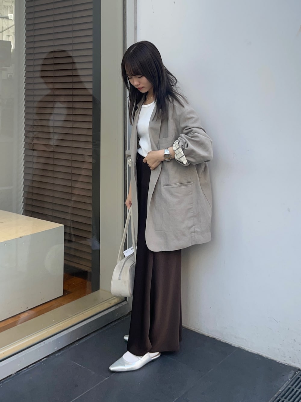 ベージュ系のその他アウター、ブラウン系のスカート、ホワイト系のタンクトップを着用したレディースの春コーディネートの3枚目の写真