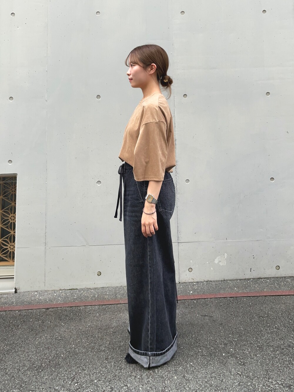 ブラック系のデニムパンツ、ベージュ系のTシャツ/カットソー、ブラック系のその他シューズを着用したレディースの秋コーディネートの2枚目の写真