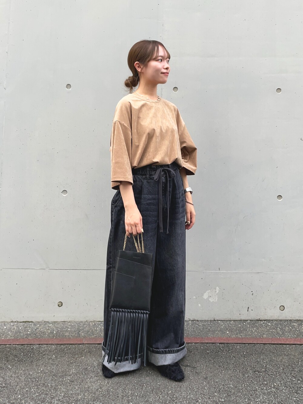 ブラック系のデニムパンツ、ベージュ系のTシャツ/カットソー、ブラック系のその他シューズを着用したレディースの秋コーディネートの6枚目の写真