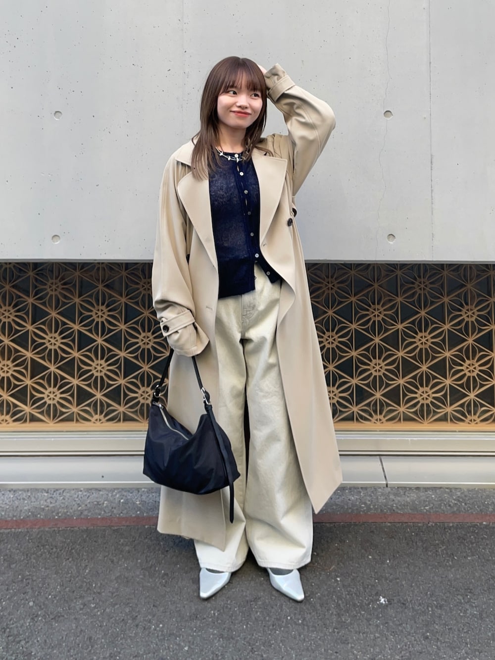 ベージュ系のトレンチコート、ブルー系のカーディガン/ボレロ、グレー系のデニムパンツを着用したレディースの冬コーディネートの6枚目の写真