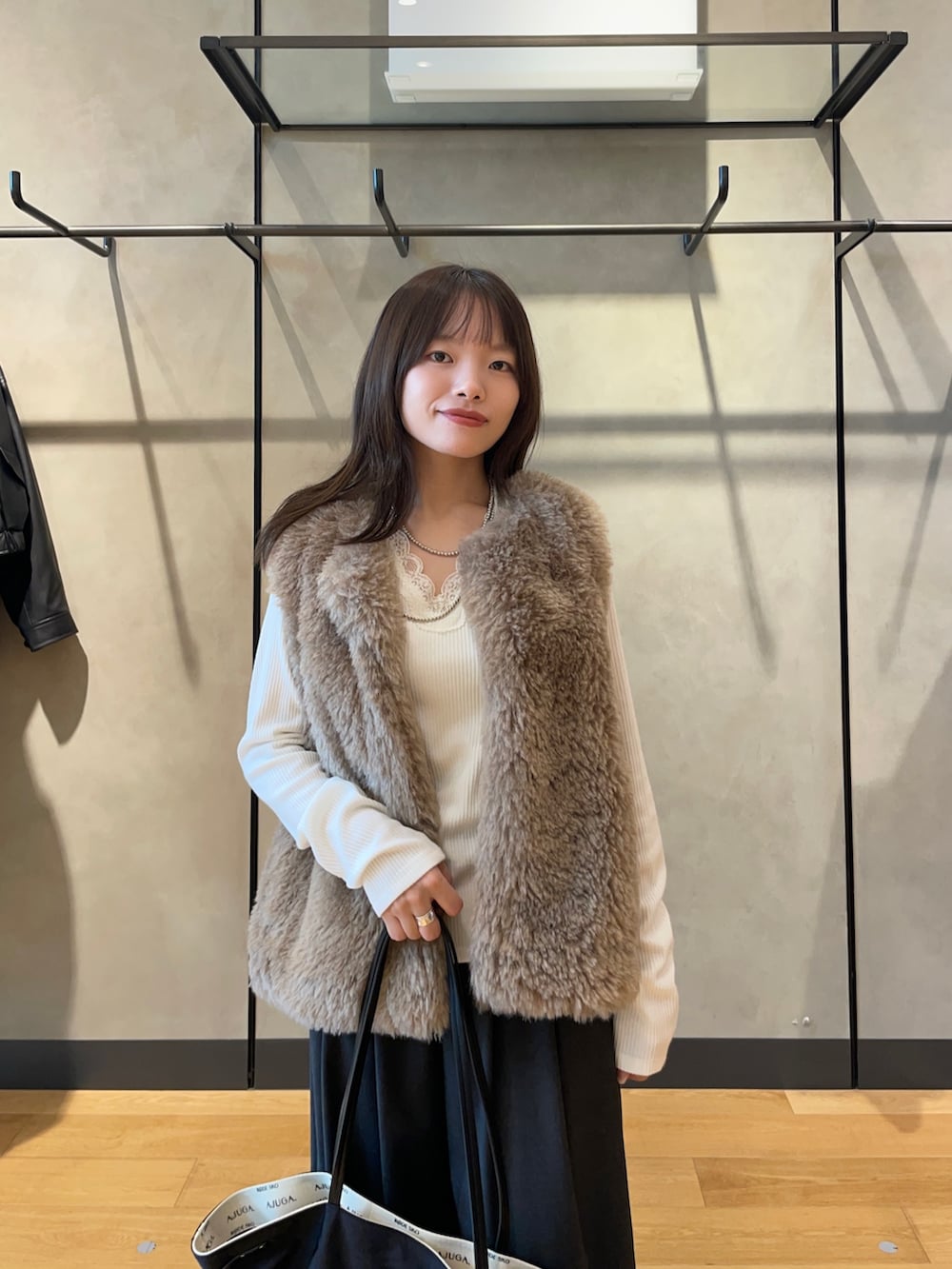ホワイト系のTシャツ/カットソー、ブラック系のパンプス、ブラック系のトートバッグを着用したレディースの秋コーディネートの2枚目の写真