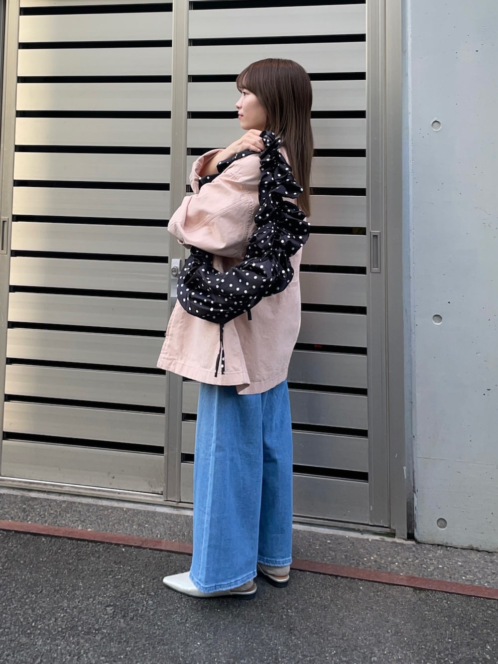 ピンク系のカバーオール、ブラック系のショルダーバッグ、ホワイト系のニット/セーターを着用したレディースの春コーディネートの3枚目の写真