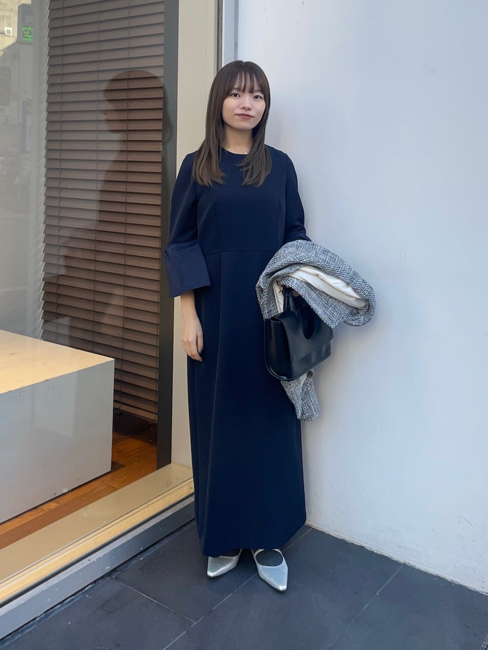 ブラック系のノーカラージャケット、ブルー系のワンピース、シルバー系のパンプスを着用したレディースの冬コーディネートの8枚目の写真