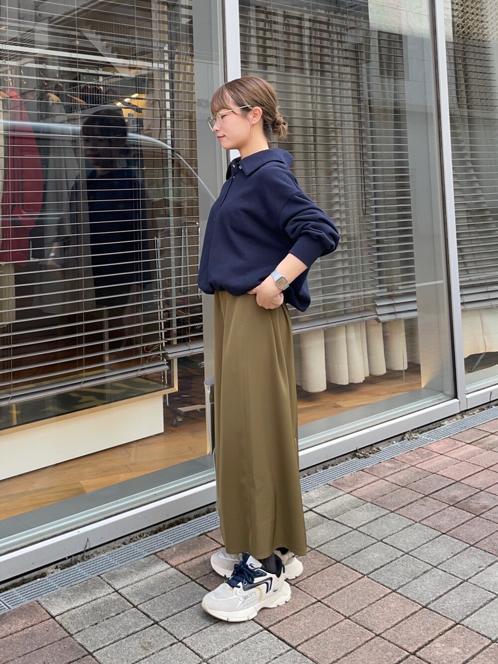 ブルー系のスウェット、グリーン系のスカート、シルバー系のショルダーバッグを着用したレディースの秋コーディネートの3枚目の写真