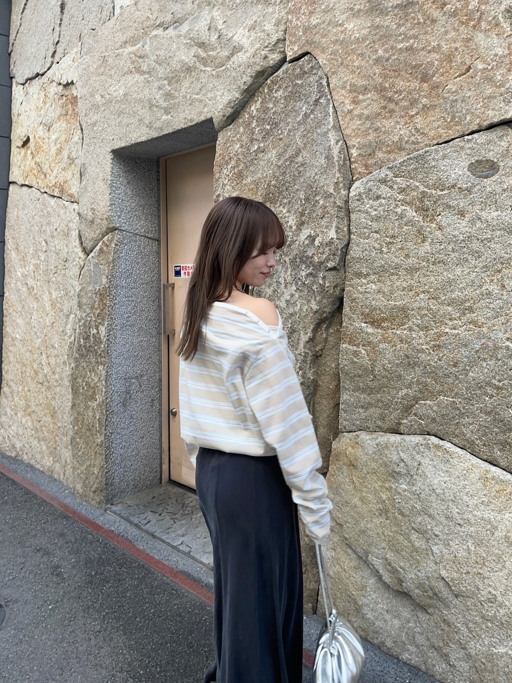 ベージュ系のTシャツ/カットソー、ブラック系のスカート、シルバー系のショルダーバッグを着用したレディースの春コーディネートの8枚目の写真