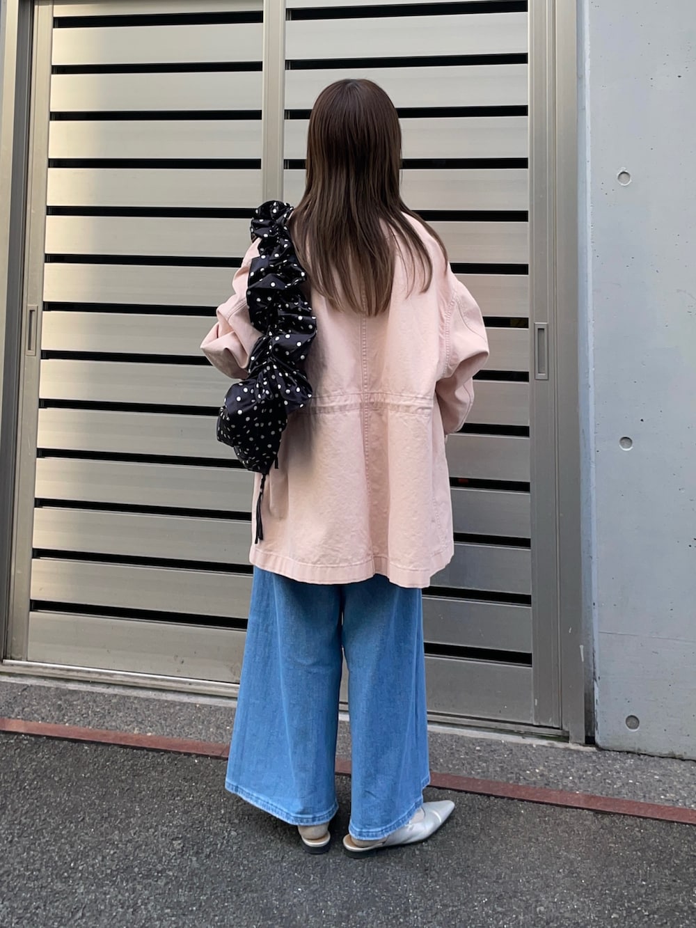 ピンク系のカバーオール、ブラック系のショルダーバッグ、ホワイト系のニット/セーターを着用したレディースの春コーディネートの4枚目の写真