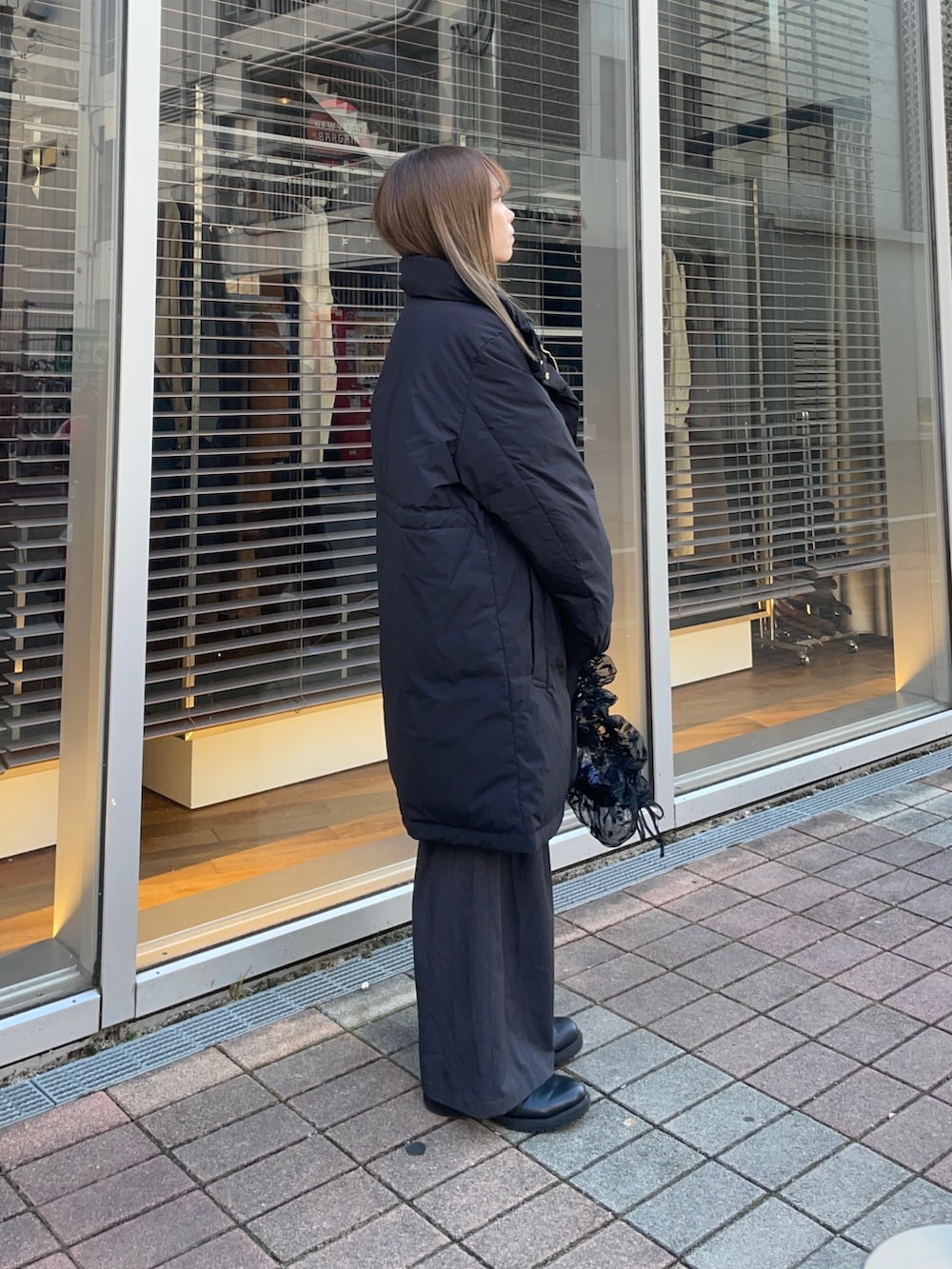 イエロー系のカーディガン/ボレロ、ホワイト系のTシャツ/カットソー、ブラック系のダウンジャケット/コートを着用したレディースの冬コーディネートの4枚目の写真