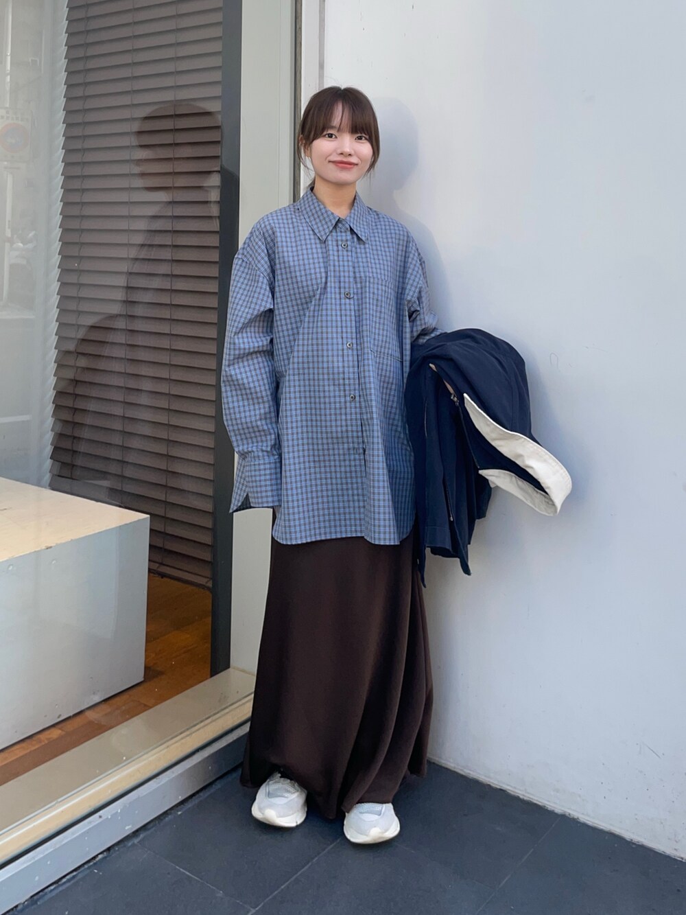 ブラウン系のスカート、ブルー系のシャツ/ブラウス、ブルー系のカバーオールを着用したレディースの春コーディネートの6枚目の写真