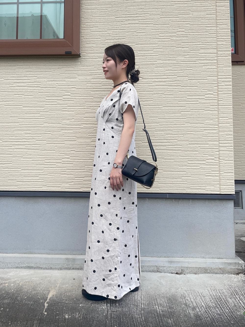 ベージュ系のワンピース、ブラック系のショルダーバッグ、ブラック系のサンダルを着用したレディースの夏コーディネートの3枚目の写真