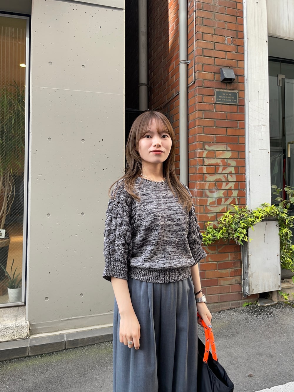 グレー系のニット/セーター、ブラック系のトートバッグ、グレー系のその他パンツを着用したレディースの春コーディネートの8枚目の写真