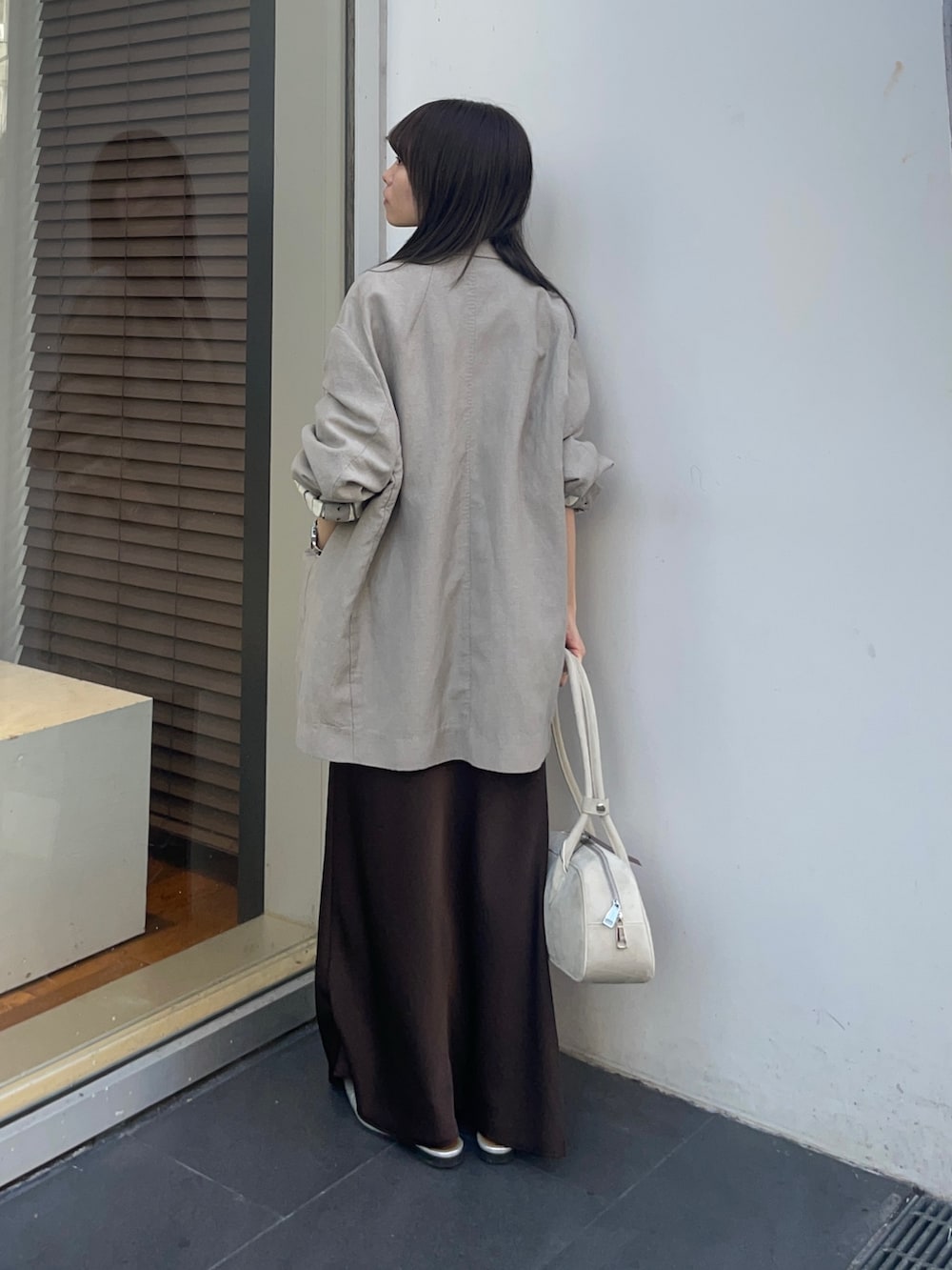 ベージュ系のその他アウター、ブラウン系のスカート、ホワイト系のタンクトップを着用したレディースの春コーディネートの4枚目の写真