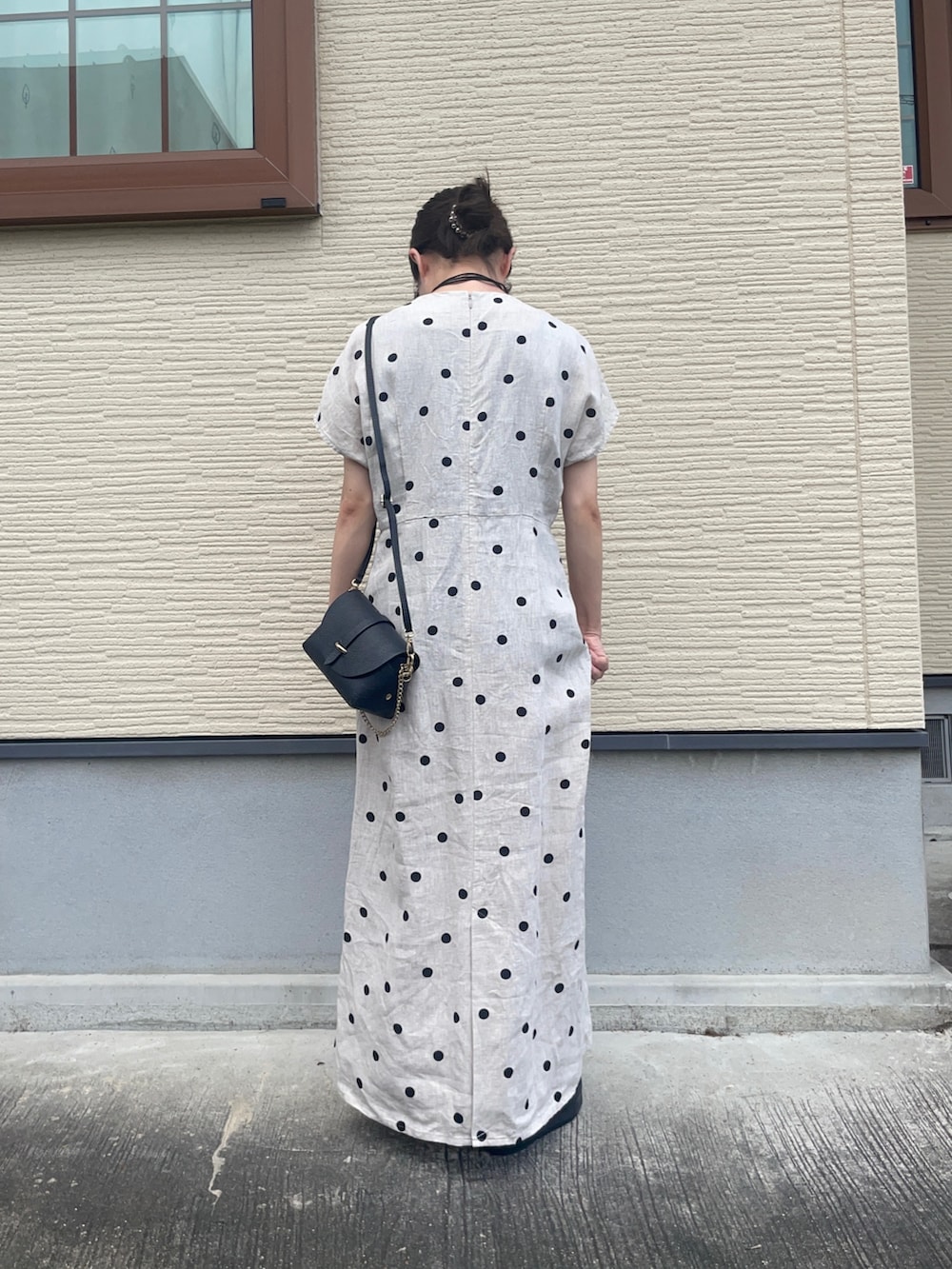 ベージュ系のワンピース、ブラック系のショルダーバッグ、ブラック系のサンダルを着用したレディースの夏コーディネートの4枚目の写真