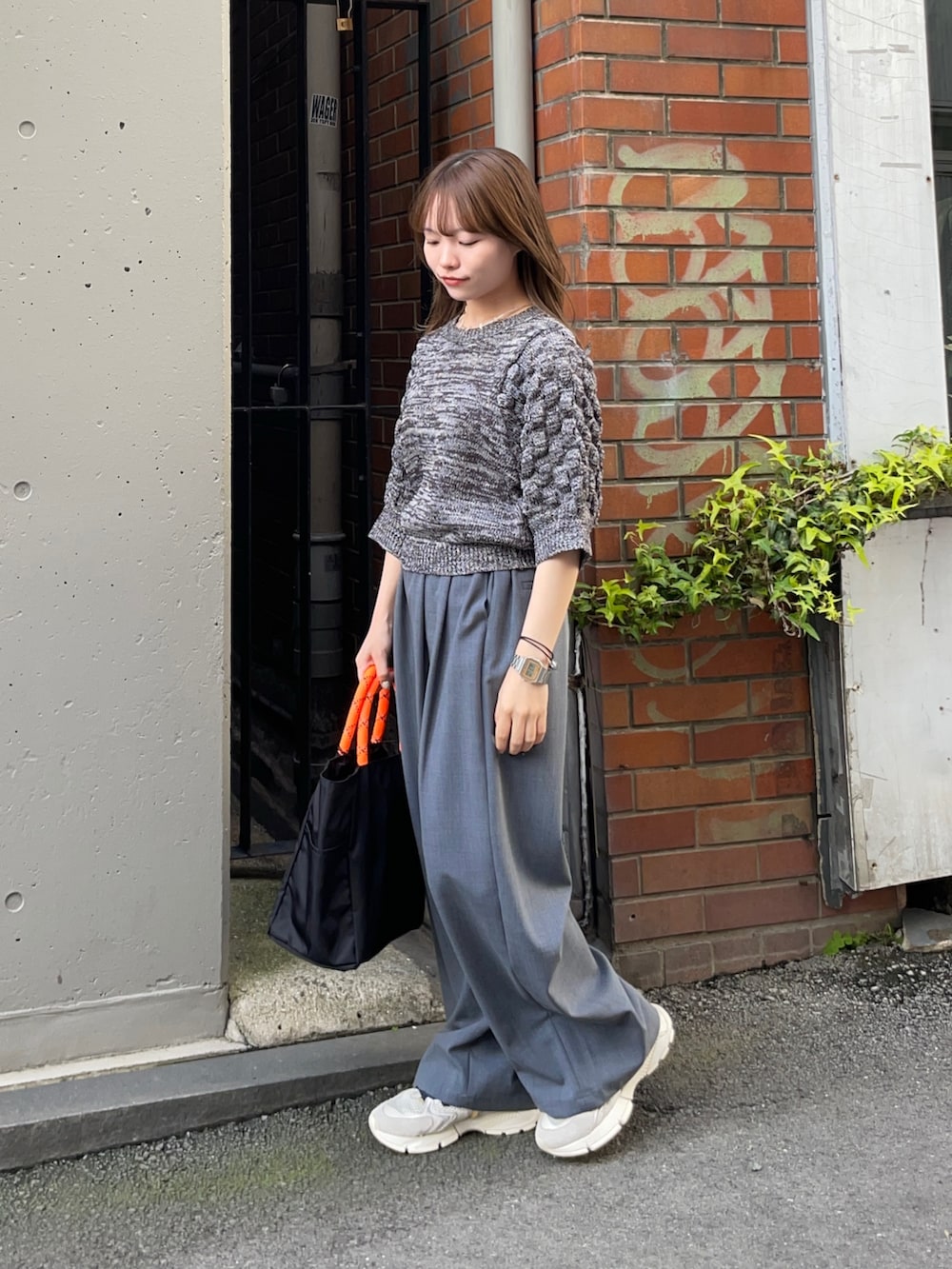 グレー系のニット/セーター、ブラック系のトートバッグ、グレー系のその他パンツを着用したレディースの春コーディネートの3枚目の写真