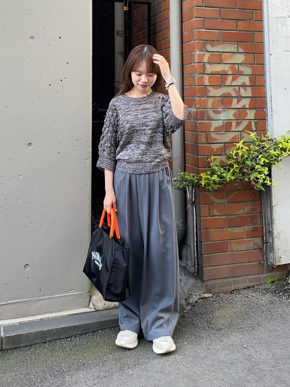 グレー系のニット/セーター、ブラック系のトートバッグ、グレー系のその他パンツを着用したレディースの春コーディネートの2枚目の写真