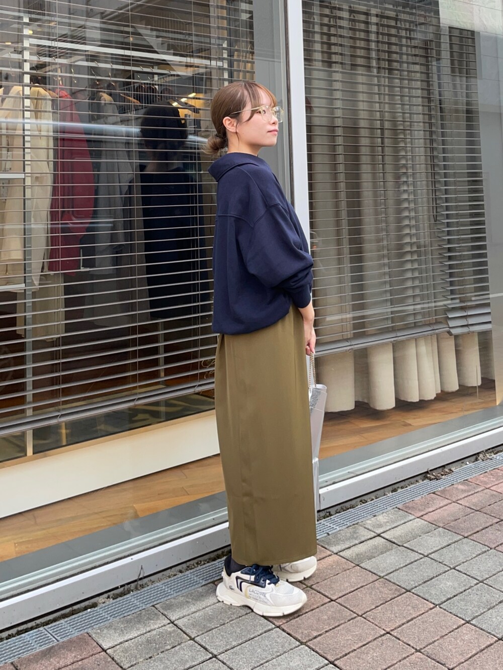 ブルー系のスウェット、グリーン系のスカート、シルバー系のショルダーバッグを着用したレディースの秋コーディネートの5枚目の写真