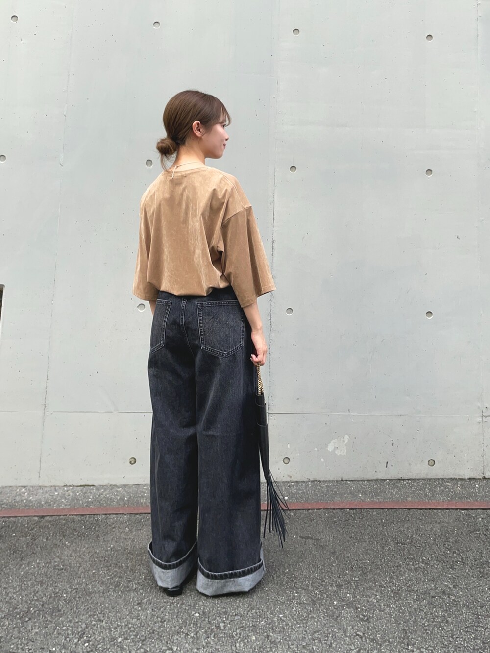 ブラック系のデニムパンツ、ベージュ系のTシャツ/カットソー、ブラック系のその他シューズを着用したレディースの秋コーディネートの3枚目の写真
